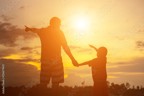 Happy dad throws the baby at sunset