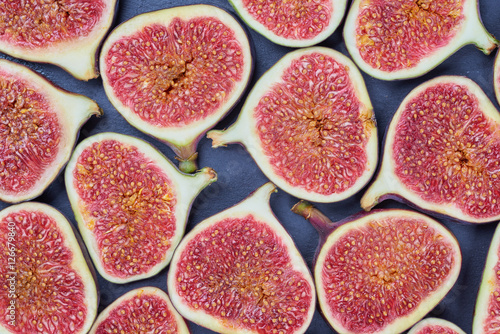 Pieces of fig on a stone board. Fruit background