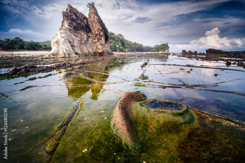 Beautiful seascape scenery of big boulder stone with green mossy at Sawarna beach, Banten, Indonesia photo