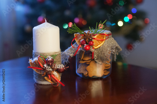 Christmas candle and сookies in a jar.  Christmas holly. Festiv photo