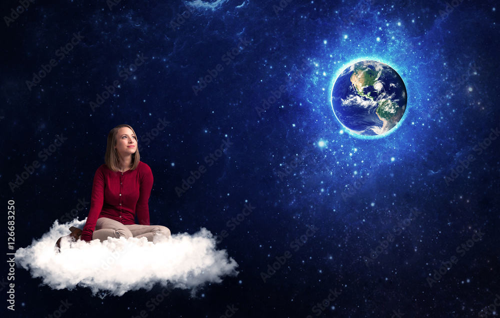 Woman sitting on cloud looking at planet earth Woman sitting on cloud looking at planet earth