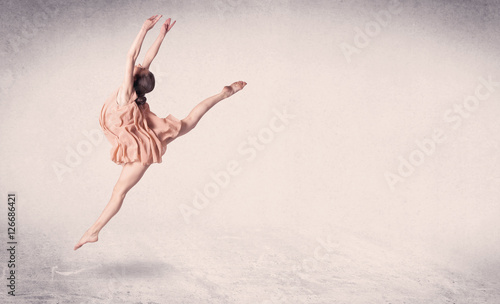 Modern ballet dancer performing art jump with empty background