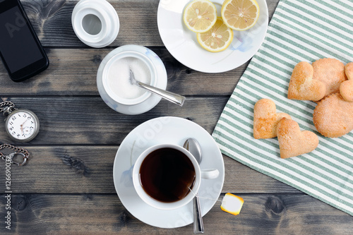 Foods of the Italian breakfast with tea and biscuits on an old wooden table, photographed from above