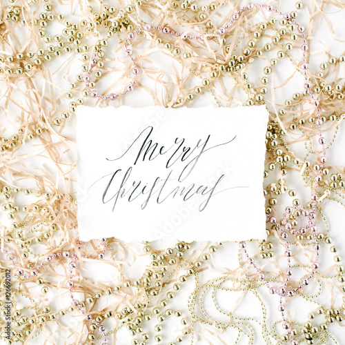 calligraphy words merry christmas and christmas tinsel decoration. flat lay, top view
