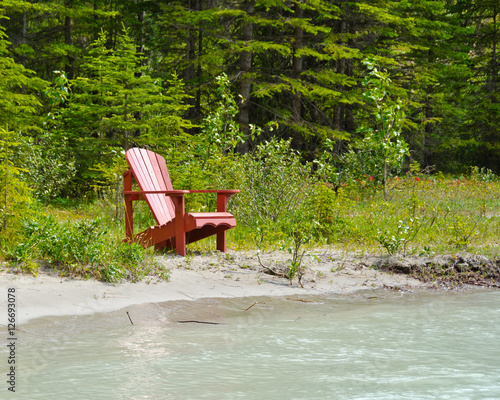 Picnic bench (chair) on the beach of the river in Canada. photo