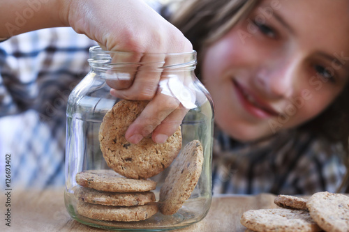 Fototapeta Young boy eating a cookie from the jar