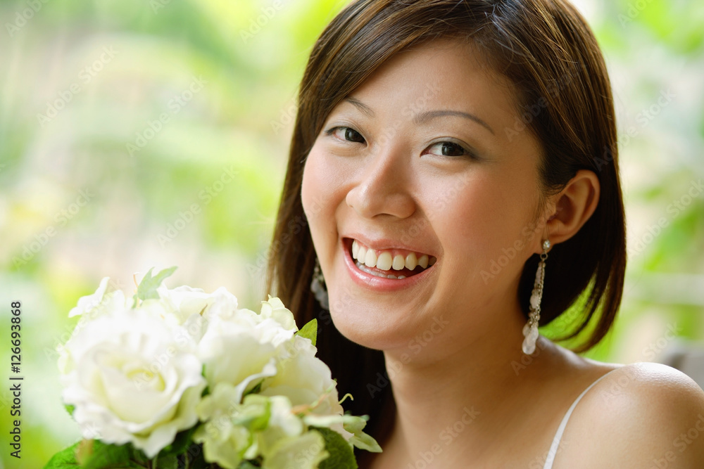 Young woman holding a bouquet of flowers, smiling Young woman holding a bouquet of flowers, smiling