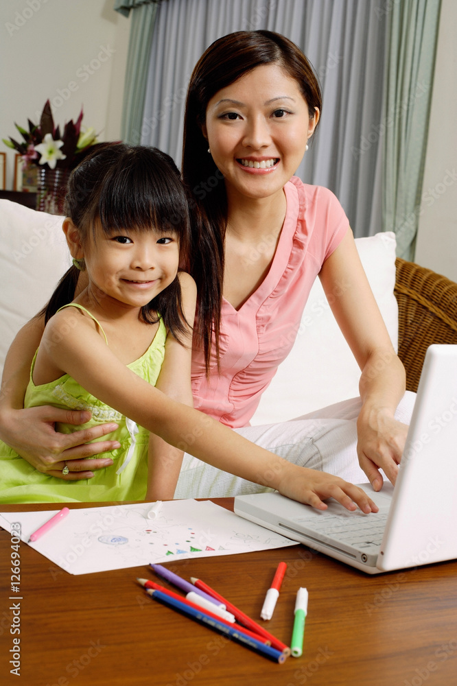Mother and daughter with laptop, looking at camera Mother and daughter with laptop, looking at camera