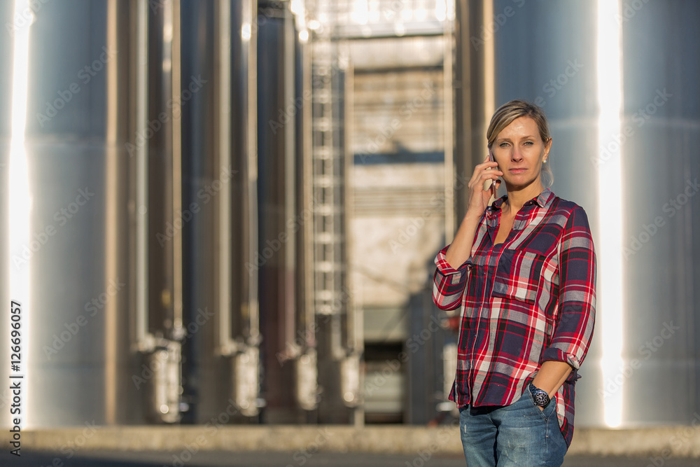 female worker speaking on mobile phone in an industrial area female worker speaking on mobile phone in an industrial area