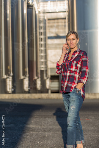female worker speaking on mobile phone in an industrial area