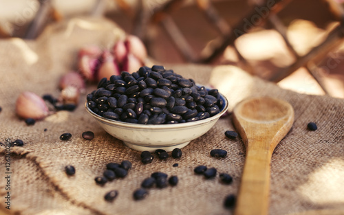 Black beans in a plate on the rustic background