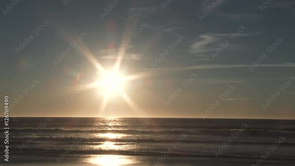 Real time beach scenic as sunsets over the Pacific Ocean from the Oregon Coast on beautiful and bright sunny day. Real time beach scenic as sunsets over the Pacific Ocean from the Oregon Coast on beautiful and bright sunny day.