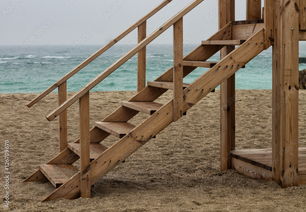 Wooden ladder beside the sea after rain