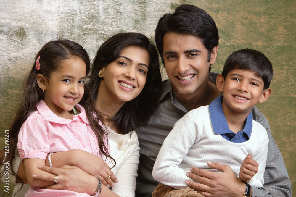 family of four smile at camera