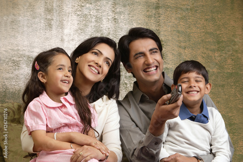 Photography father holds phone up in family portrait
