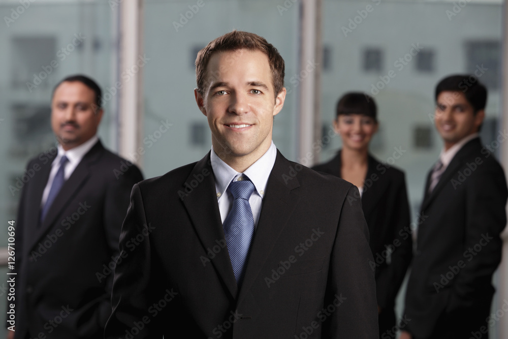 caucasian man standing in front of colleagues caucasian man standing in front of colleagues