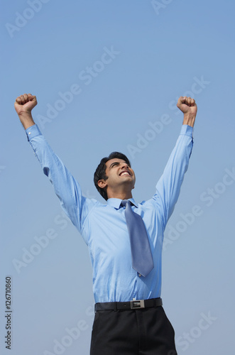 smiling businessman with both fists in the air