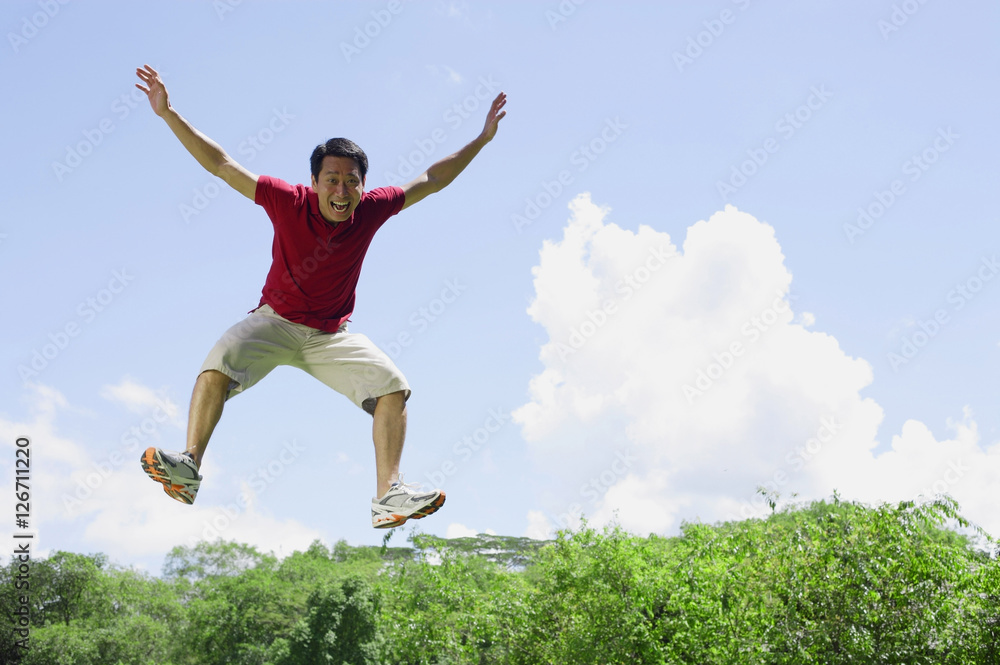 Man jumping in mid air, arms outstretched