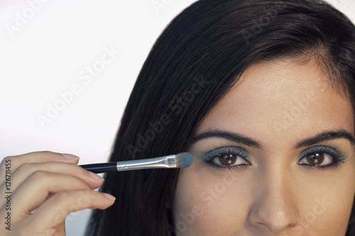 Cropped shot of woman putting on eye makeup