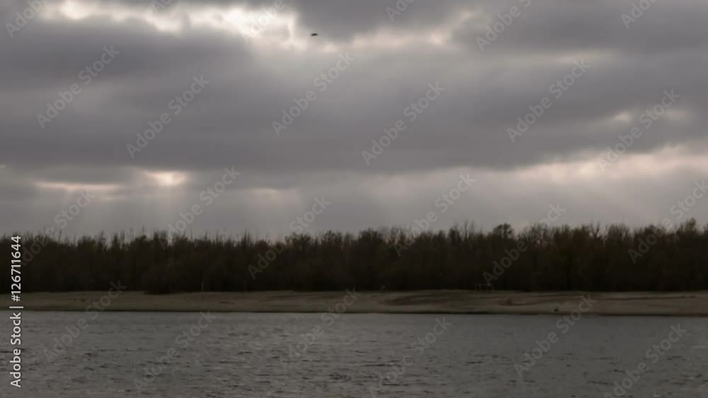 Autumn landscape time lapse. Dark clouds with sun rays fly over tops of forest trees Autumn landscape time lapse. Dark clouds with sun rays fly over tops of forest trees