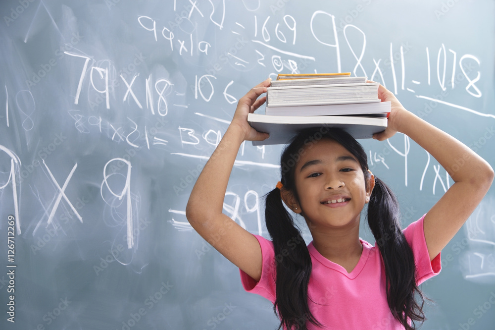 girl with books stacked on head