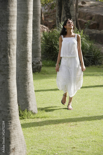 teen girl walking on grass in park