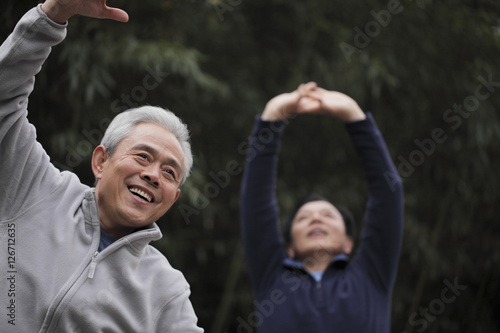 Two older men stretching outdoors