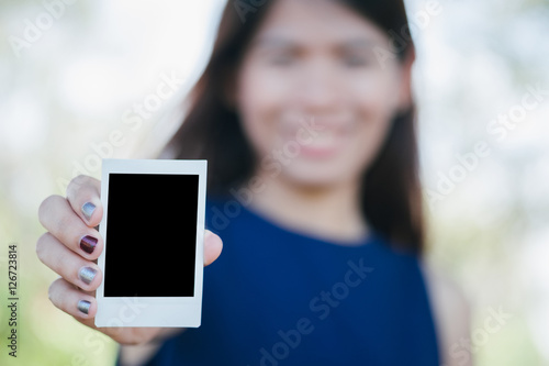 Asia Woman hold photo instant on hand. Blank instant photo with nature background. relationship concept.