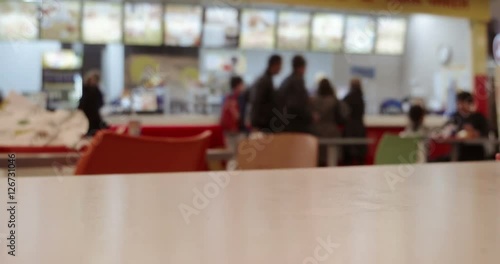 Time lapse shot of crowd in mall food court view over table top