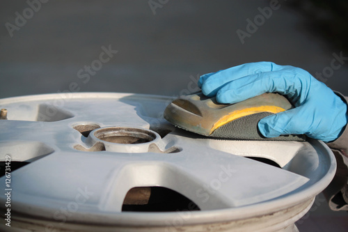 uomo carrozziere a lavoro su ruota auto