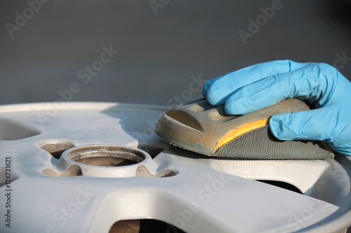 uomo carrozziere a lavoro su ruota auto
