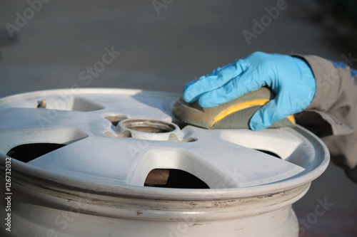 uomo carrozziere a lavoro su ruota auto