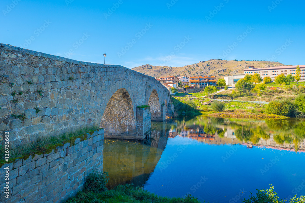Medieval bridge over a river in sunlight