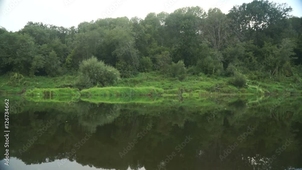 View of the coast of the river from the passing kayak. View of the coast of the river from the passing kayak.