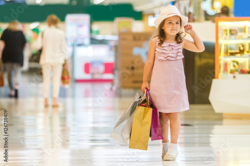 cute little girl in fashionable hat on shopping. portrait of a k