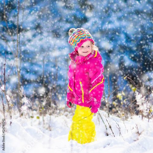 Child having fun in snowy winter park