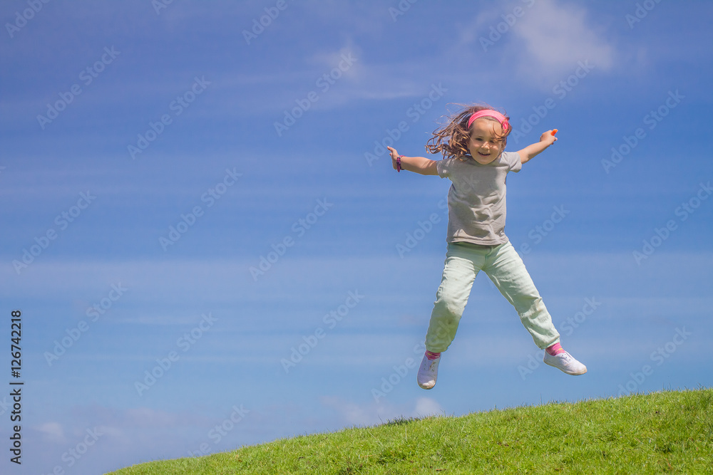 outdoor portrait of young happy child girl jumping on blue sky b outdoor portrait of young happy child girl jumping on blue sky b