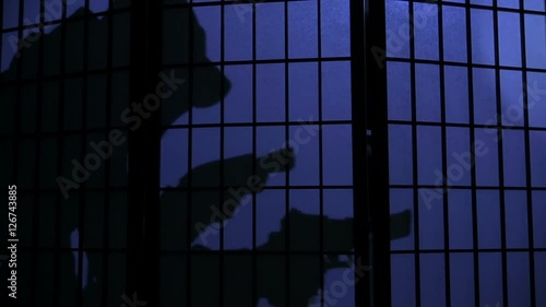 silhouette of a sneaking burglar with flashlight and gun