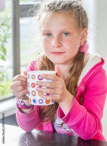 portrait of young happy child girl drinking photo