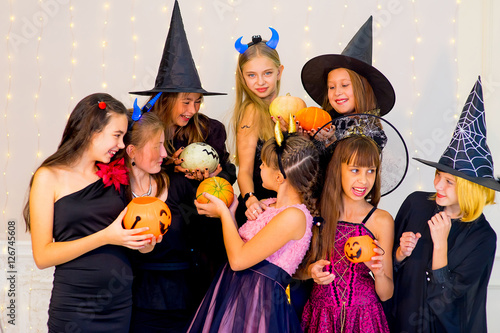 Happy group of teenagers in Halloween costumes posing on camera