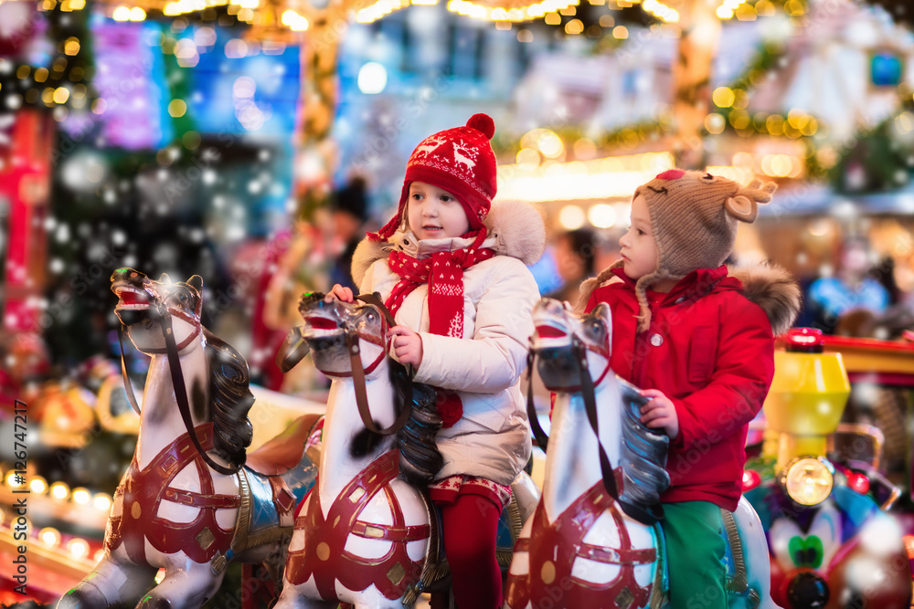 Children riding carousel on Christmas market