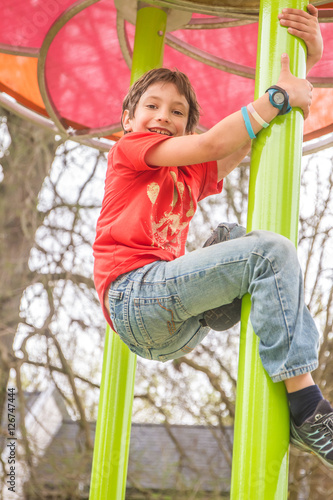 Happy young boy on the playground at the day time