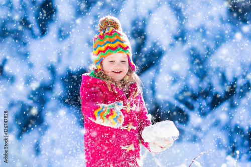 Child having fun in snowy winter park