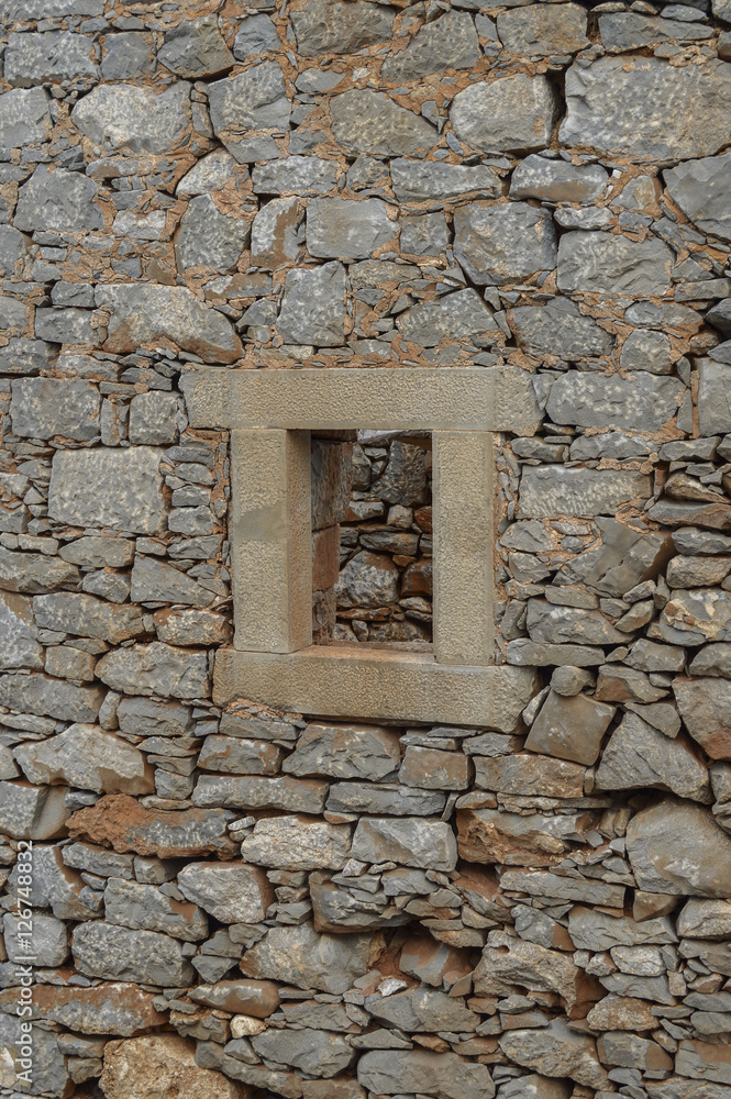 Old stone window in ruins on the Greek island of Crete
