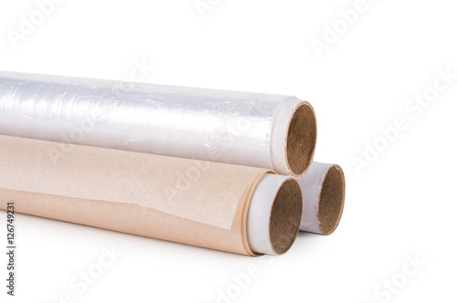 One roll of plastic wrap  one roll of aluminum foil and One roll of parchment paper for household use on a light background. Isolation.