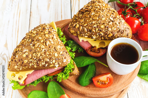 Burger sandwich with ham, cheese, tomatoes and lettuce