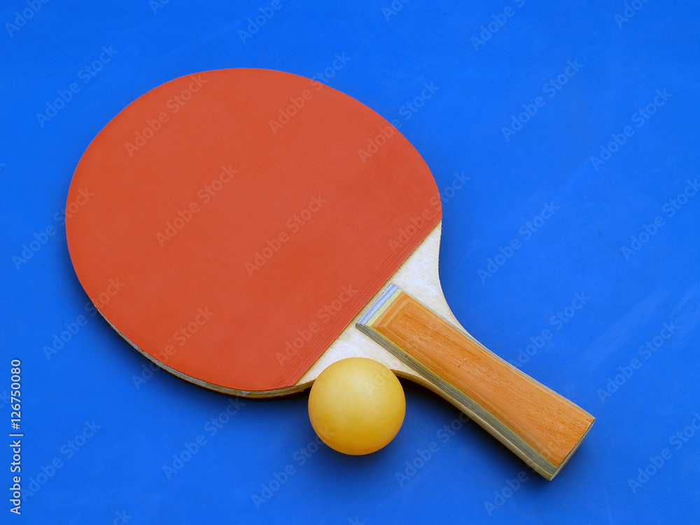 single red table tennis ping pong racket with plastic ball on blue court single red table tennis ping pong racket with plastic ball on blue court