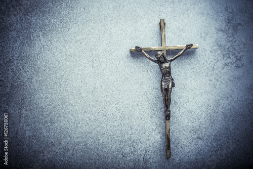 Crucifix of Jesus on the cross with stone background. Symbol of christian religion and belief. Image composed with copy space.