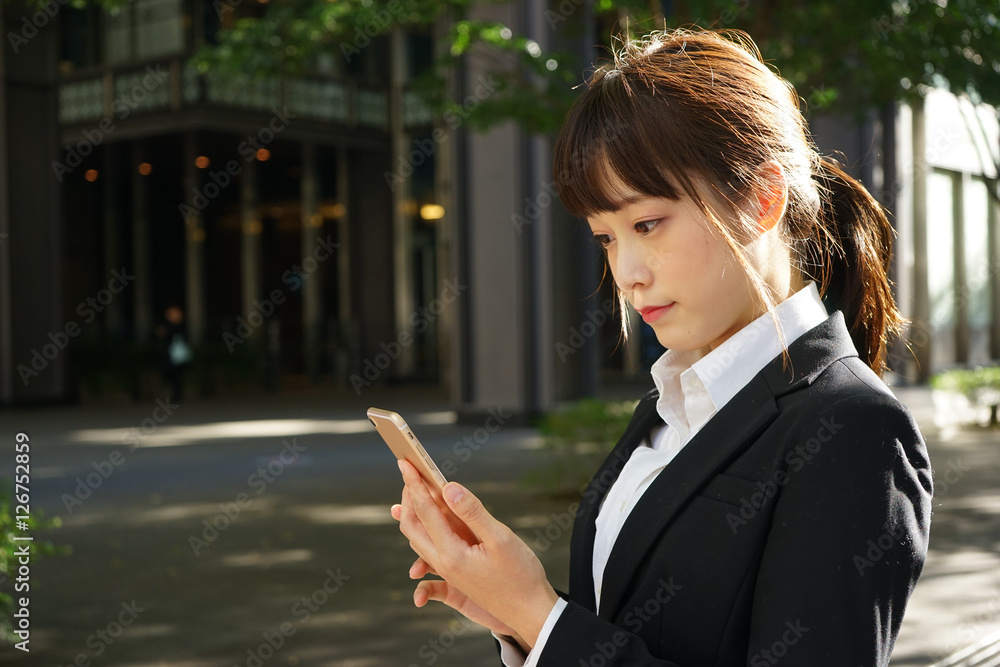 Young woman using a smart phone on the street