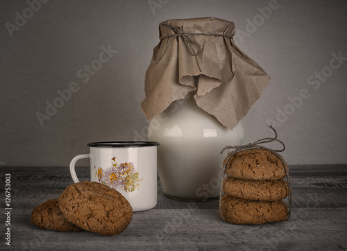cup and jar of milk and homemade cookies on wooden table